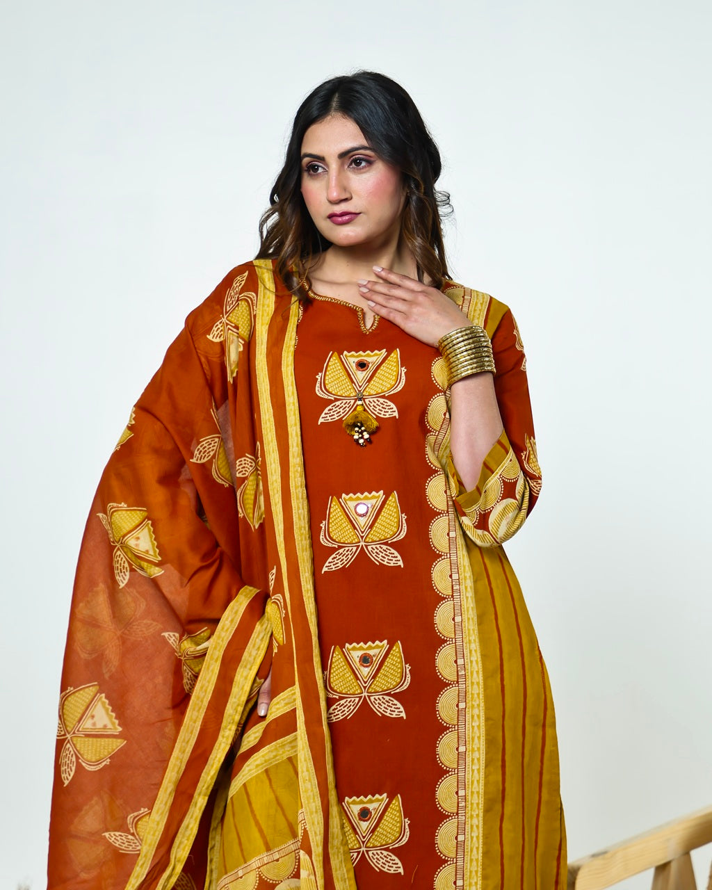 Navya-Rust Cotton Suit Set with Mustard Lotus Print, Mirror Work, Handwork Neckline & Tasselled Dupatta